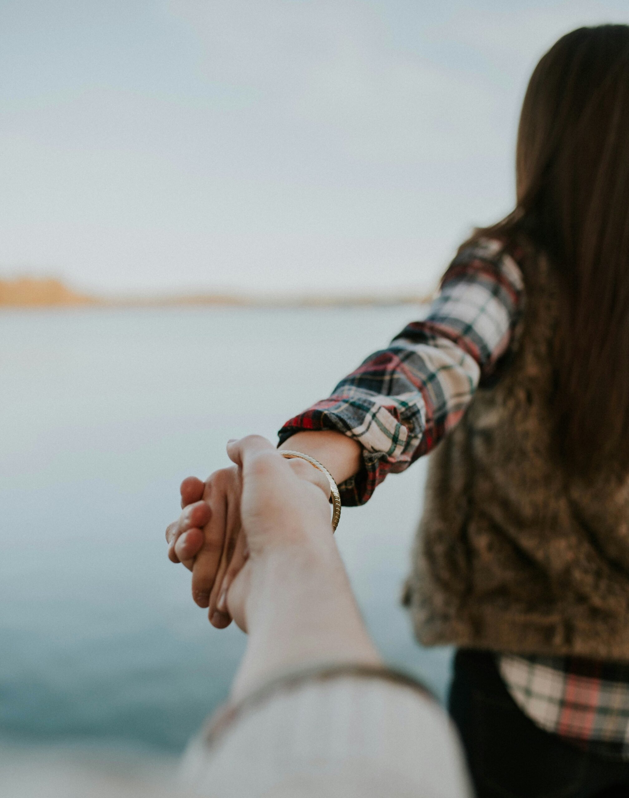 Couple holding hands on the beach.